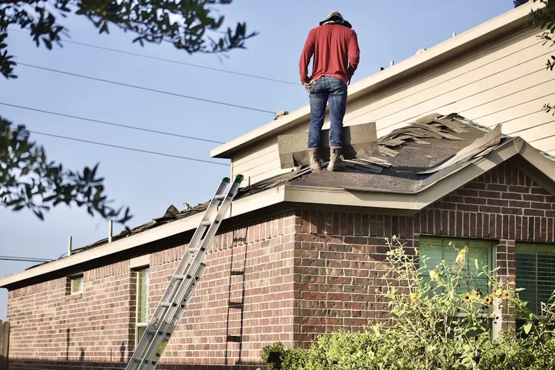 Professional roofer working on a residential roof in Sandy Boulevard